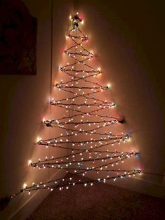 a lighted christmas tree in the corner of a room with lights on it's branches