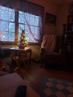 a living room filled with furniture and a christmas tree in front of a large window