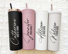 four personalized travel mugs are lined up in a row on top of a table