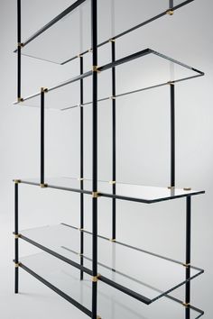 a glass shelf with gold trimmings on the top and bottom, against a white background