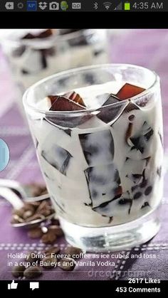 two glasses filled with ice cream and topped with coffee beans on a purple tablecloth