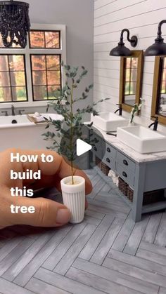 a person is holding a cup with a plant in it and the words how to build this tree