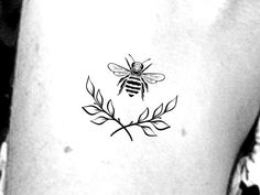 a black and white photo of a bee on the back of a woman's stomach