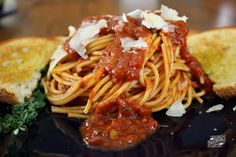 spaghetti with tomato sauce and parmesan cheese on toasted bread, ready to be eaten