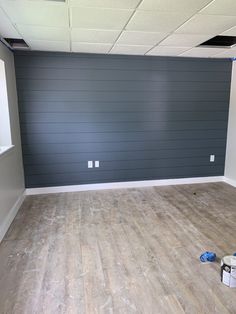 an empty room with hard wood floors and gray walls