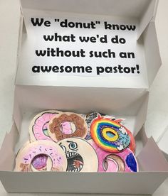 a box filled with lots of different types of doughnuts and a sign that says we donut how what we'd do without such an awesome