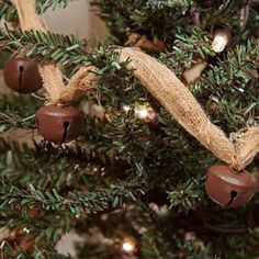 a close up of a christmas tree with brown bells and burlocks on it