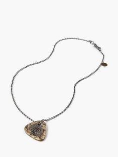 a necklace with a heart shaped pendant hanging from it's side on a chain