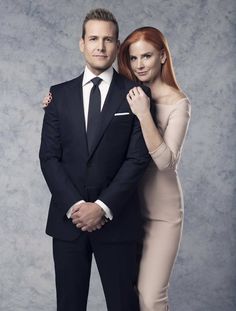 a man in a suit and woman in a dress posing for a photo with their arms around each other