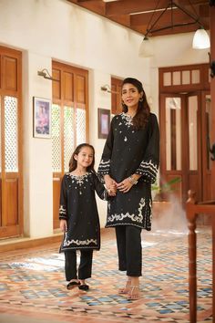 2 Piece Embroidered Suit for Women : A classic monochromatic design envisioning captivating details that make this two-piece staple a perfect style statement for you and your little one. Description -- Kameez (Shirt) : Black Embroidered Paper Cotton Shirt.Lining included. -- Shalwar (Trouser) : Black Pants. Country of Origin : Pakistan General Care Instruction : Hand Wash recommended or dry clean. Color may bleed so please be mindful of other items with it. General Disclaimer -- Size chart provi Classic Long Sleeve Sets For Eid, Matching Fitted Sets With Long Sleeve, Fitted Long Sleeve Matching Sets, Elegant Festive Cotton Sets, Classic Cotton Festive Sets, Classic Cotton Sets For Festive Occasions, Classic Festive Cotton Sets, Classic Eid Festive Sets, Classic Festive Sets For Eid