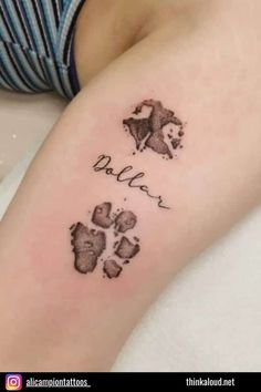 a small tattoo with the name and paw prints on it