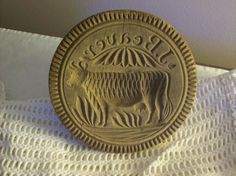 a metal plate with the word peace on it sitting on a white cloth next to a wall