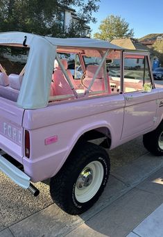 a pink pick up truck parked on the street