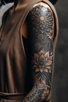 a woman's arm with flowers on it and a brown dress underneath her sleeve