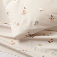 the sheets and pillow cases are made up with different designs on them, including palm trees