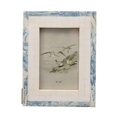 two seagulls flying over the water in a blue and white tile photo frame