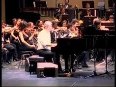 an image of a conductor and orchestra performing