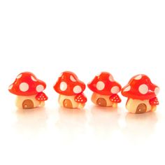 three small red mushrooms sitting next to each other