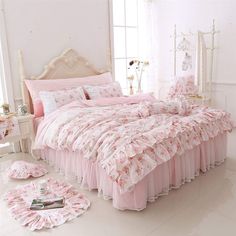 a white bed with purple bedspreads and pillows on top of it in a room