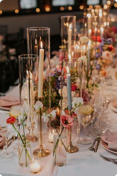 the table is set with candles, flowers and wine glasses for an elegant wedding reception