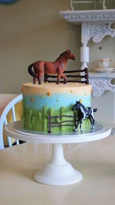 there is a cake that has two horses on it and one horse in the fence