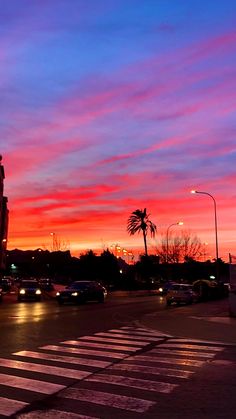 the sun is setting over a city street