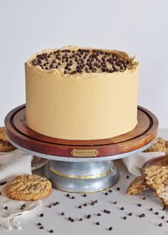 there is a cake with chocolate chips on the top and cookies around it, along with other desserts