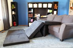 a living room filled with furniture and a book shelf full of books on top of it