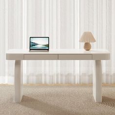 a white table with a laptop on it in front of a curtained window and a lamp