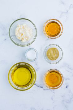 four bowls with different ingredients in them sitting on a marble counter top next to each other