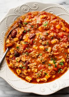 a white bowl filled with pasta and meat soup