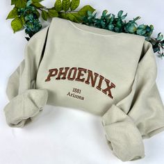 Phoenix Embroidered Sweatshirt Message me for other cities! -Embroidered Sweatshirt   - Unisex Sweatshirt -Gildan brand *(jerseesor Port & Co brands may be used to fulfill any back orders that may occur) - Design is 6.8in wide for all  sweatshirt sizes  please message me for any questions. Thank you! Cotton Campus Top With Letter Embroidery, Cotton Tops With Letter Embroidery For Campus, Fall College T-shirt With Embroidered Logo, College T-shirt With Embroidered Logo For Fall, Cotton Sweatshirt With Letter Embroidery For Campus, Embroidered Text T-shirt For College In Fall, Fall College Embroidered T-shirt, Winter College T-shirt With Embroidered Text, College Winter T-shirt With Embroidered Text