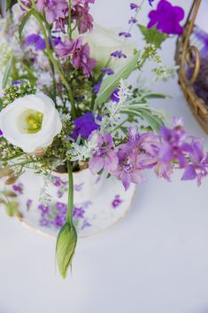 purple and white flowers in a vase on a table