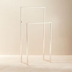 two white frames sitting next to each other on top of a floor in front of a wall