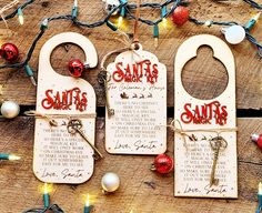 three wooden door hangers with santa's wishes on them and christmas lights in the background