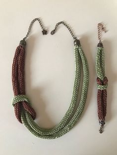 two necklaces with different colors and designs on them, one has a silver clasp