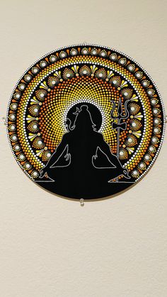 a woman is sitting in the middle of a circle with an intricate design on it