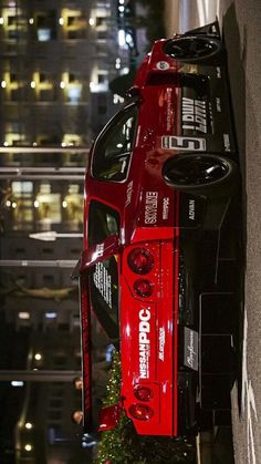 a red car parked on the side of a building