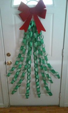 a door decorated with green, red and white streamers that have bows on them