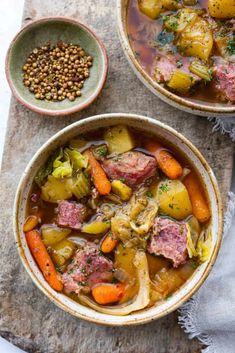 two bowls filled with meat and vegetables on top of a table