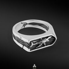 a silver ring with an image of shark and fish on the inside, in black background