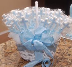 a white basket with blue ribbon on top of a table