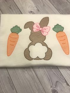 an embroidered bunny with carrots on it