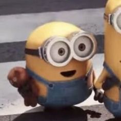 two minions from despicable me are standing next to each other on the street