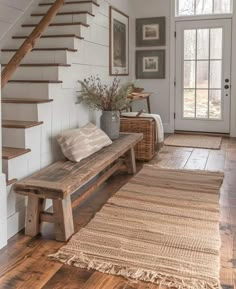 a wooden bench sitting under a stair case