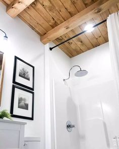 a bathroom with wood ceiling and white walls