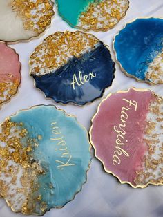 four decorated cookies with the words after and after written in gold, blue, pink, and green on them