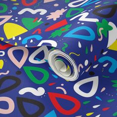 a blue wallpaper with colorful shapes and lines on it's surface, as well as a roll of tape