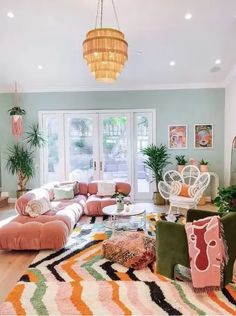 a living room filled with furniture and a chandelier hanging over the top of it