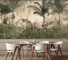 an elephant and giraffe mural in a dining room with white chairs around a wooden table